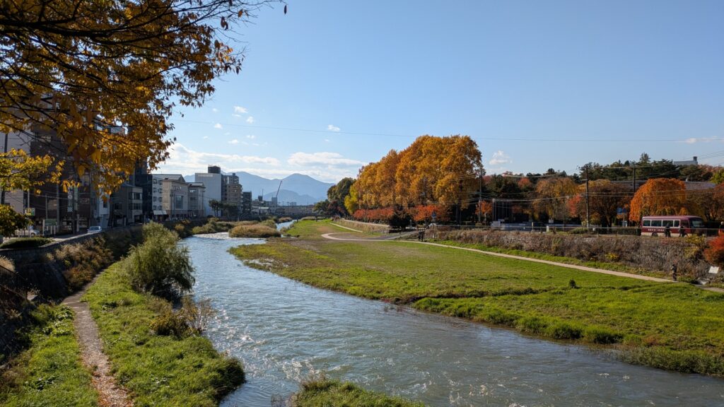 秋の川沿いと街並み