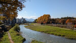 秋の川沿いと街並み